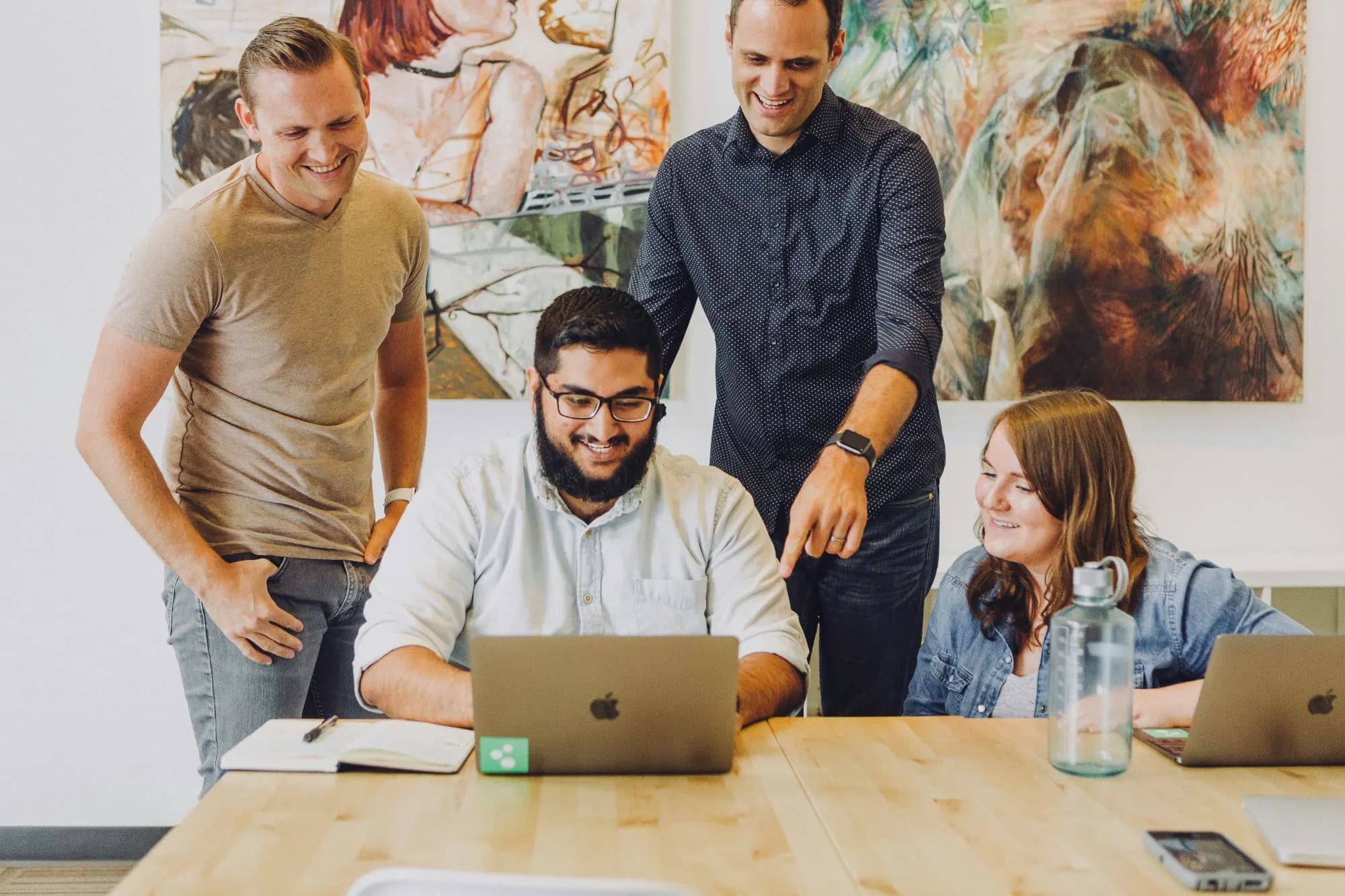 A team reviewing work together on a laptop